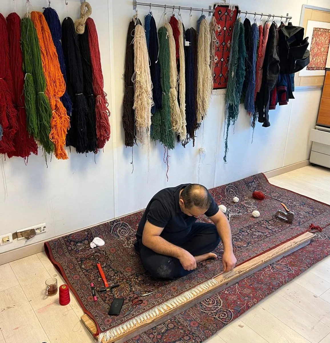À l'atelier : reprise d'un tapis, laines de restauration au mur